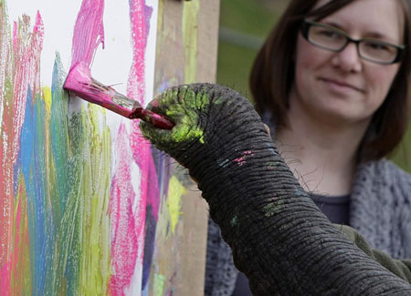 Five, an African elephant, holds a paint brush as it paints a picture of Lottie and Adam Smith at West Midlands Safari Park in Bewdley, central England April 7, 2009.